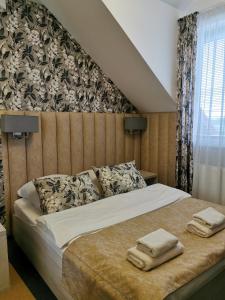 a bedroom with a bed with two towels on it at Rezydencja Pod Pieprzówkami in Zalesie Gorzyckie