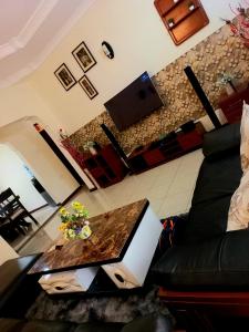 un soggiorno con tavolo e computer portatile di Ariel comfort home ad Arusha
