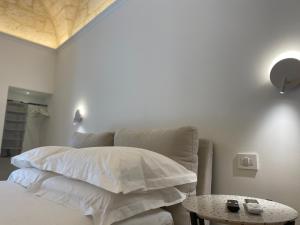 a bedroom with a bed with white pillows and a table at Dimora Zonno in Bari