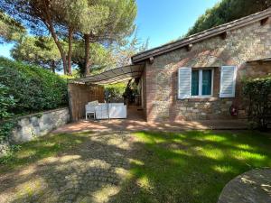 a brick house with a table and a chair in a yard at Villaggio I Sorbizzi in Marina di Bibbona