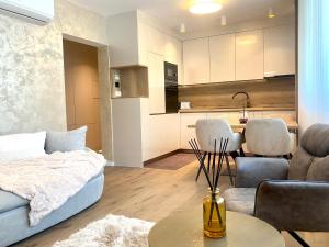 uma sala de estar com um sofá, uma mesa e uma cozinha em Citylux Grand Apartment em Zagreb