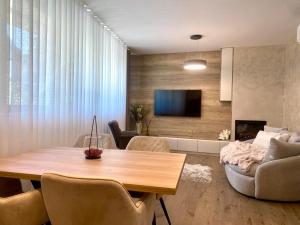 uma sala de estar com uma mesa, um sofá e uma televisão em Citylux Grand Apartment em Zagreb
