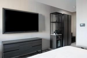 a bedroom with a flat screen tv on the wall at The Artisan at Tuscan Village, Salem, a Tribute Portfolio Hotel in Salem