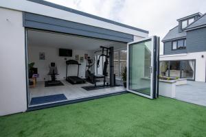 einen Fitnessraum mit Glasschiebetüren und grünem Gras in der Unterkunft Maycliffe in Shanklin
