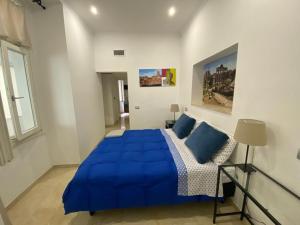 a bedroom with a blue bed and a window at Stradivari Suite Roma in Rome