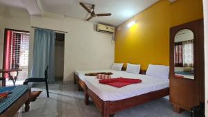 ein Schlafzimmer mit einem Bett und einer gelben Wand in der Unterkunft Hotel Citi Heart in Port Blair