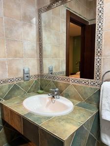 y baño con lavabo y espejo. en HOSTAL TREVELEZ, en El Ejido