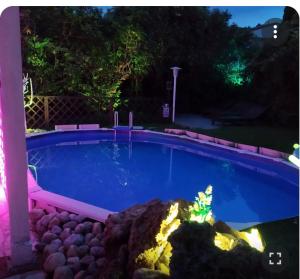 una piscina notturna con luci in cortile di Villa Luna Lombarda a Salò