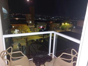 een balkon met uitzicht op de stad in de nacht bij Aeroporto 14km, apto com wi-fi, self check-in e varandinha in Lagoa Santa