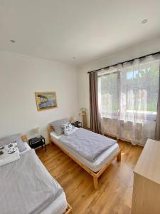 1 dormitorio con 2 camas y ventana en Luca Apartman, en Gyenesdiás