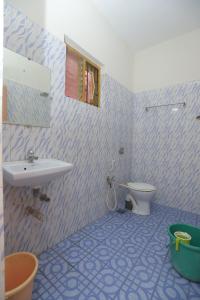 a bathroom with a sink and a toilet at Pritams Cottages Guest House in Palolem