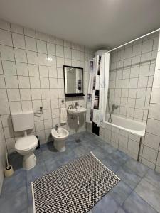 a bathroom with a toilet and a tub and a sink at Apartman Milla in Ljubuški