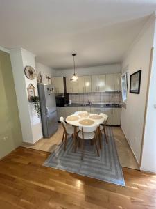 a kitchen with a table and chairs in a room at Apartman Milla in Ljubuški