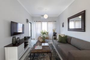 a living room with a couch and a tv at One More Night Apartment E202 in Gaborone