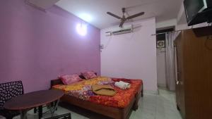 a bedroom with a bed with a table and a ceiling fan at Hotel Citi Heart in Port Blair