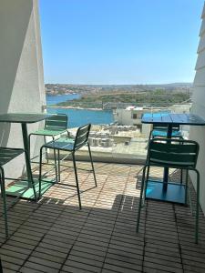 two chairs and tables on a balcony with a view at Eleven by Warren Collection in Sliema