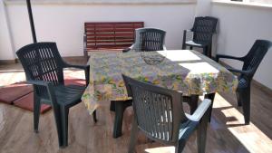 einem Tisch mit vier Stühlen und einem Tischtuch darauf in der Unterkunft Paola Confort House in Avola