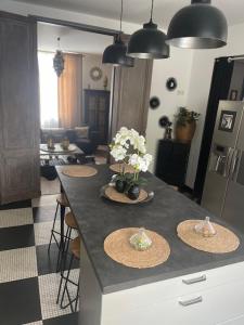 a kitchen with a counter with three plates and flowers on it at BARREAU in Libourne