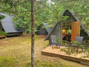 een hut in het bos met een houten terras bij Liivakõrtsi kämping in Rõmeda