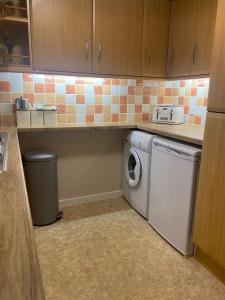 a small kitchen with a washer and dryer at Seaview in Lossiemouth