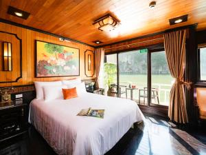 um quarto com uma cama e uma grande janela em Victory Boutique Cruise em Ha Long