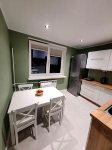 a kitchen with a white table and a refrigerator at Apartament Wrzos in Cisna