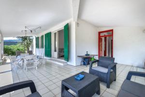 ein Wohnzimmer mit Stühlen, einem Tisch und einer Terrasse in der Unterkunft Casa Camilla in Procchio