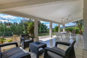 ein Wohnzimmer mit einem Tisch und Stühlen sowie eine Terrasse in der Unterkunft Casa Camilla in Procchio