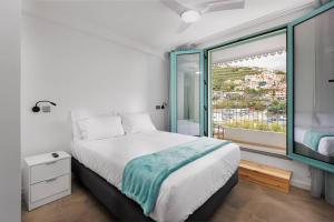 a bedroom with a bed and a large window at Villa Belafonte in Câmara de Lobos