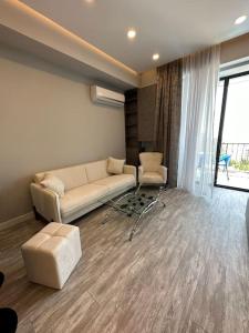 sala de estar con sofá y ventana en New Apartment In Yerevan (108) en Ereván