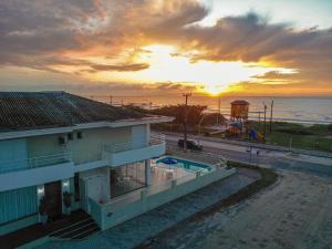 a view of a house with a sunset in the background at Hotel Vila ÁguaMar in Itapoa