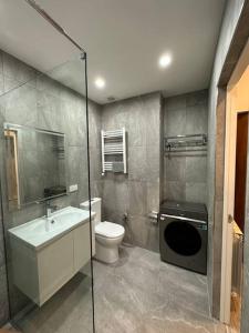 y baño con aseo, lavabo y ducha. en New Apartment In Yerevan (108) en Ereván