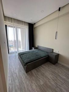 1 dormitorio con cama y ventana grande en New Apartment In Yerevan (108) en Ereván