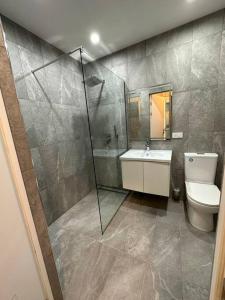 y baño con ducha, aseo y lavamanos. en New Apartment In Yerevan (108), en Ereván