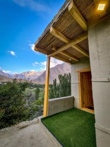 una casa con un porche con césped verde en kungrah resort ghulkin, en Sumaiyar