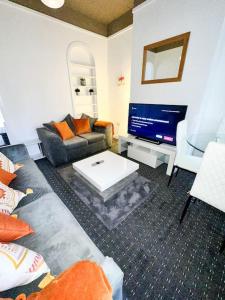 a living room with a couch and a tv at Modern Town House - Coventry in Coventry