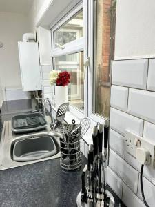 a kitchen counter with a sink and a window at Modern Town House - Coventry in Coventry