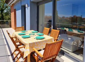 una mesa y sillas en un patio con vistas a un balcón en Apartamento nuevo en Sant Antoni de Calonge en Calonge