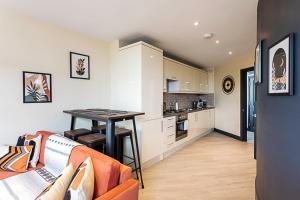 a living room with a table and a kitchen at Crystal Palace Residence II in London