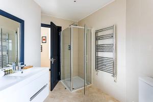 a bathroom with a glass shower and a sink at Crystal Palace Residence II in London