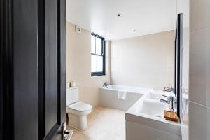 a bathroom with a toilet and a sink and a tub at Crystal Palace Residence II in London