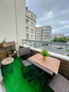 d'un balcon avec une table, des chaises et de l'herbe verte. dans l'établissement Le Dobrée - Centre - Charme & Confort - 4p - 55m2, à Nantes