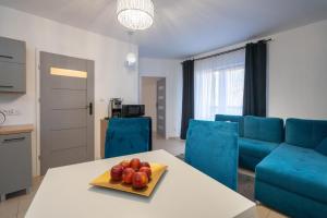 a kitchen and living room with a table with fruit on it at Trzy Sosny Apartamenty Okrzei 1c in Szklarska Poręba