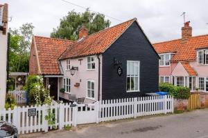 a black and white house with a white fence at The Black House, Wangford in Beccles