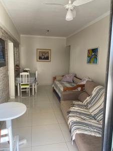 ein Wohnzimmer mit einem Sofa und einem Tisch in der Unterkunft Enseada guaruja in Guarujá