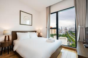 een slaapkamer met een groot wit bed en een groot raam bij Luxury Gold Apartment 86 : D1- Mension , Rooftop Pool - District 1 in Ho Chi Minh-stad