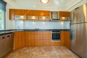 a kitchen with wooden cabinets and a stainless steel refrigerator at In the hearth of city, seaview. in Alanya