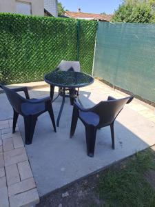 2 Stühle und ein Tisch und ein Stuhl auf einer Terrasse in der Unterkunft Hexagon Apartment in Temerin