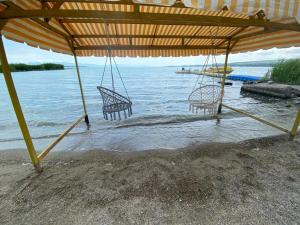 two chairs sitting under an umbrella on a beach at VILLA VIP in Sevan