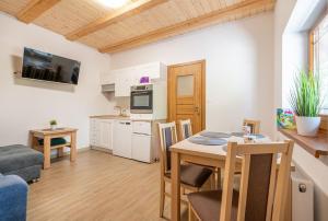 una cucina e un soggiorno con un tavolo e un divano di APARTAMENTY STODOŁA a Jezierzany Altre 8 foto